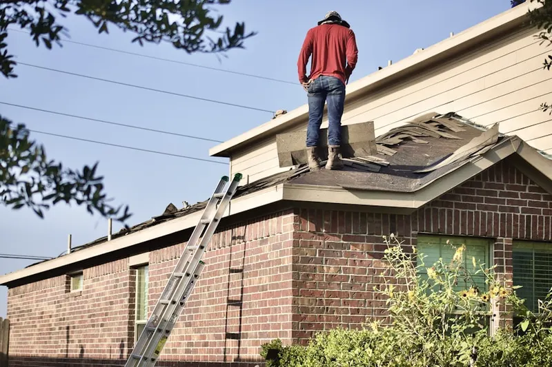 Professional roofer working on a residential roof in Mine Falls Park